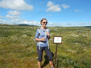 Her står Inger ved skiltet som markerer grensen til nasjonalparkern.