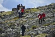Bildet viser åtte personer i gruppen på vei ned en steinet skråning.