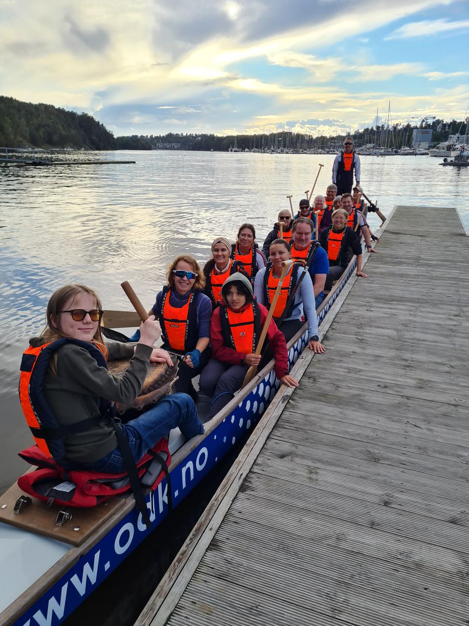 Dragebåt med 14 padlere, trommis foran og styrmann med styreåre bak.