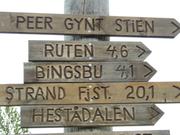 Bildet viser mange skilt på en stolpe. Skiltene peker til Peer Gynt stien, Ruten, Bingsbu, Strand fjellstue og Hestådalen.
